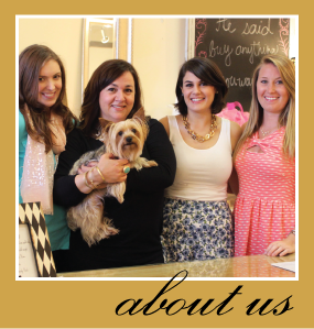 Photo of the owner and 3 of her team members.  The owner is holding a cute dog.